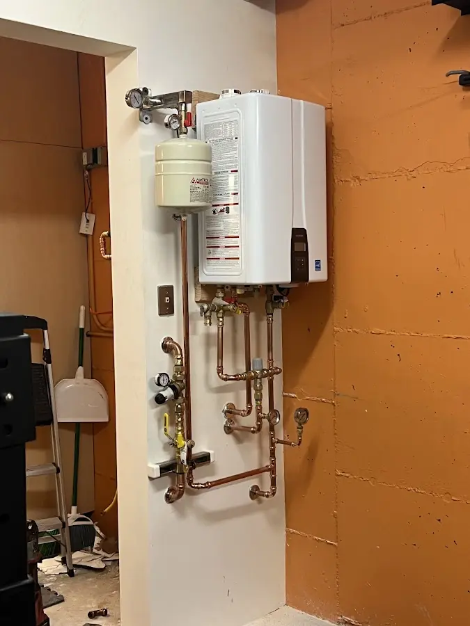 Plumbing technician inspecting water heater connections in Manila
